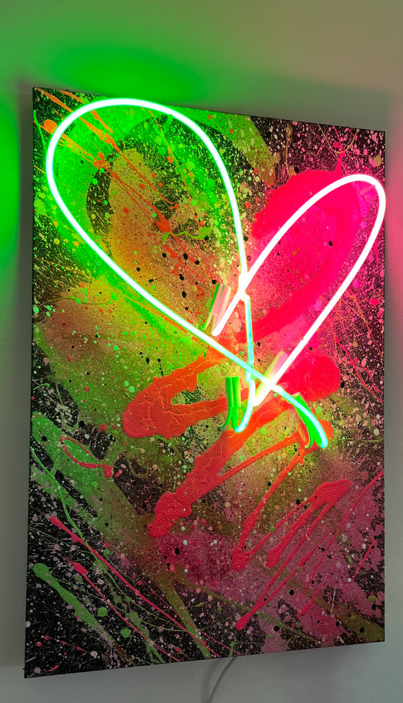 Pink and green neon heart wall art glowing in modern living room décor