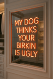 Bold glass neon sign reading 'My Dog Thinks Your Birkin is Ugly,' designed in Los Angeles in vibrant colors.